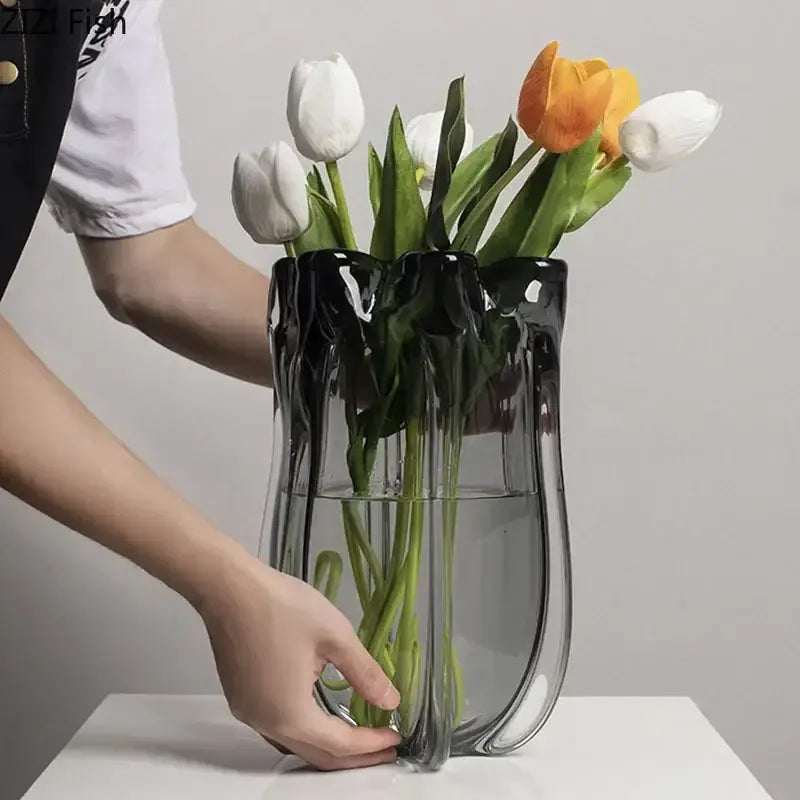 A decorbites glass vase hydroponics desk decoration in sleek translucent black glass holds white and orange tulips