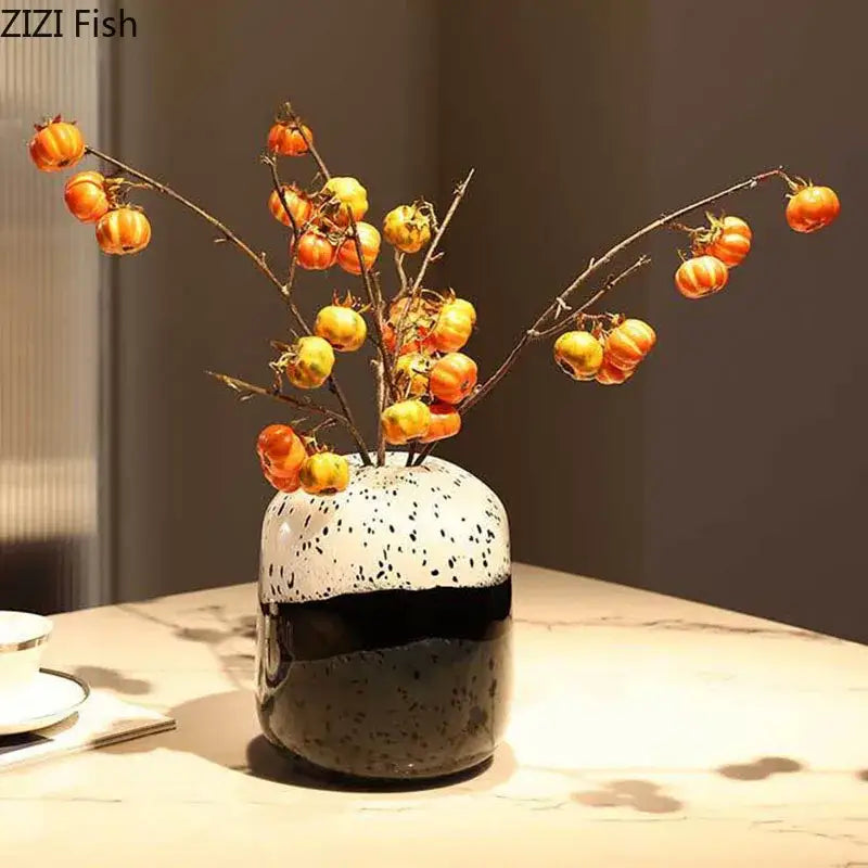 Speckled ceramic decorbites glass vase with black and white two-tone design holding orange and yellow berries ideal for hydroponics flower use