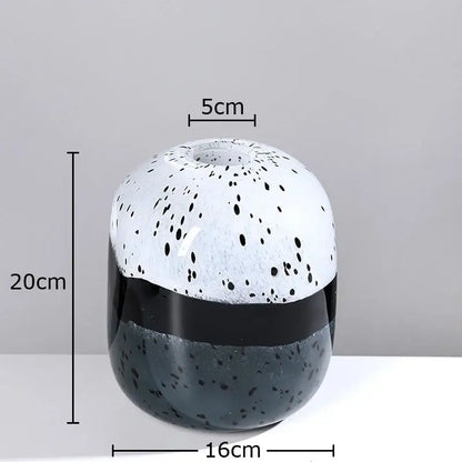 A decorbites glass vase hydroponics flower pot with speckled white black upper half and glossy black gray base