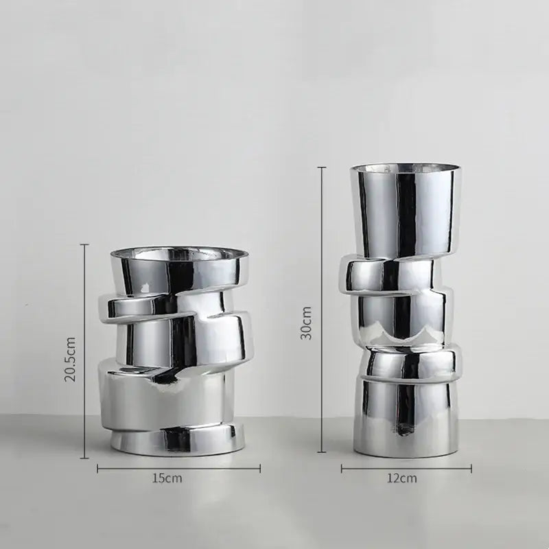 Two sleek metallic decorbites glass vases with twist shape cylindrical segments and reflective chrome finish for decoration