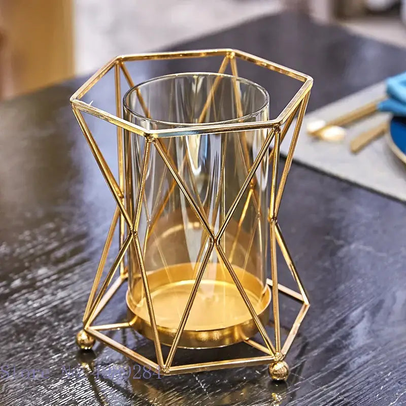 Gold geometric metal frame holding a clear DecorBites glass vase metal cylinder for flower arrangement and wedding decor