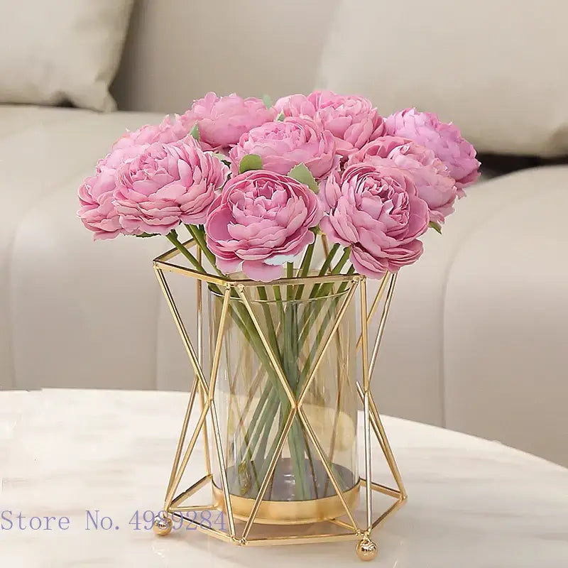 A decorbites glass vase with pink artificial peonies encased in a gold metal frame geometric flower arrangement