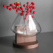 Clear glass vase terrarium by decorbites with wooden base holding red berry branches for home decoration