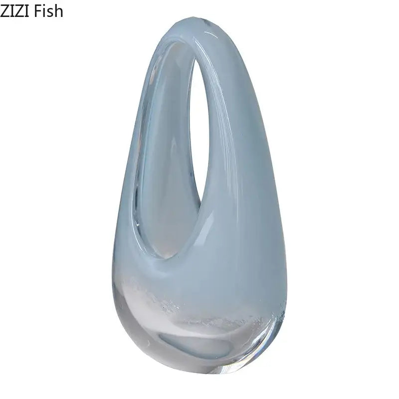 A sleek translucent light blue decorbites glass vase terrarium with a teardrop shape and elegant open loop top