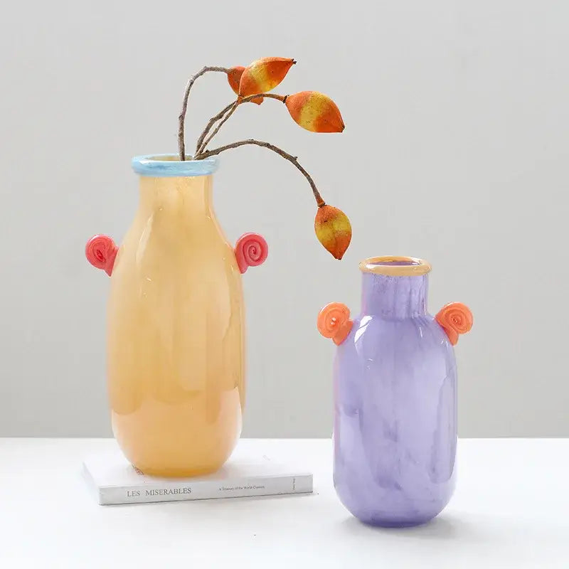 A decorbites glass vase with candy handle features a yellow glass body pink spiral handles and a light blue rim