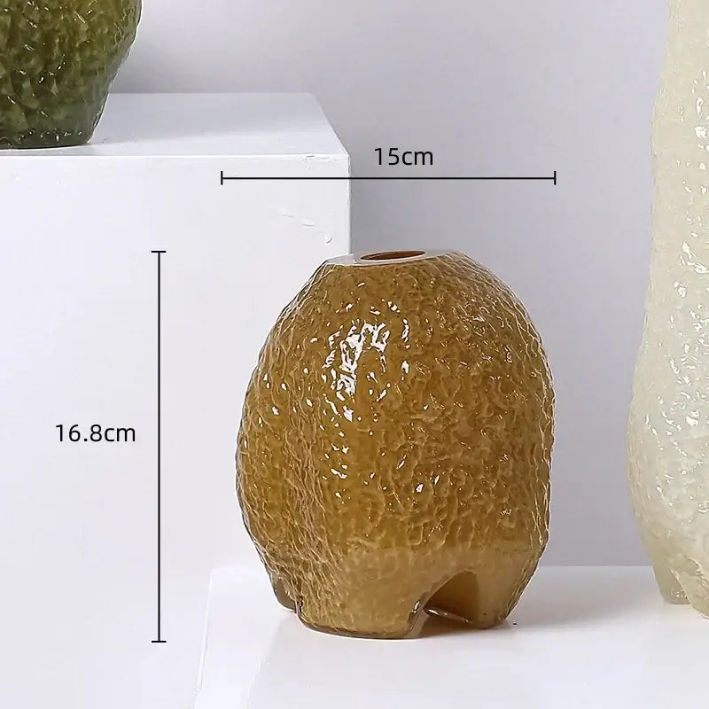 A glossy brown ceramic decorbites glass vase shaped like an avocado with irregular patterns for flower arrangement