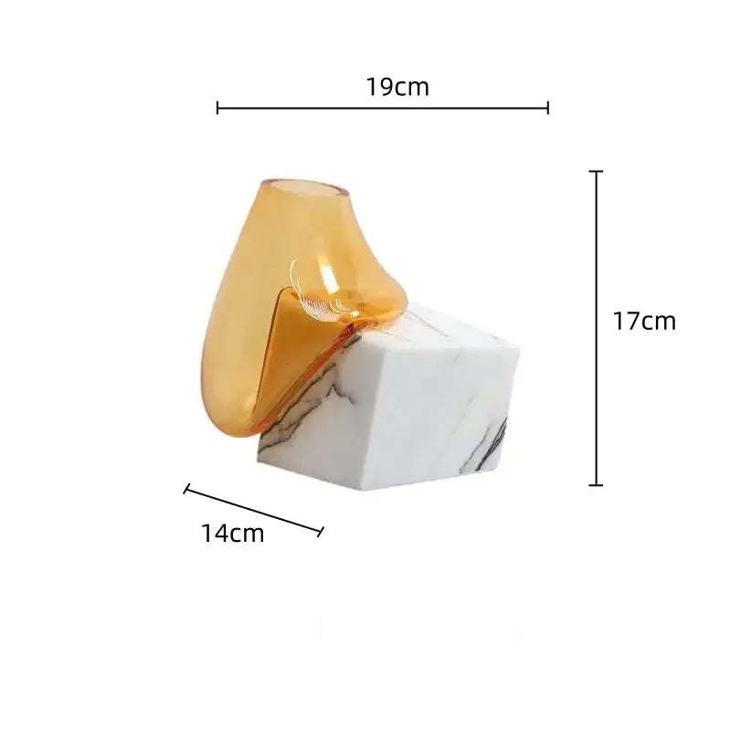 Amber-colored DecorBites glass vase with sleek modern teardrop shape resting on white marble base for elegant décor