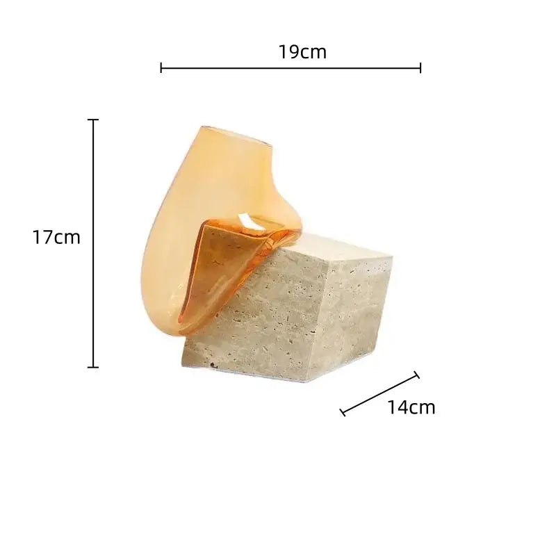 Translucent amber decorbites glass vase with smooth curved form on textured marble base for elegant home décor