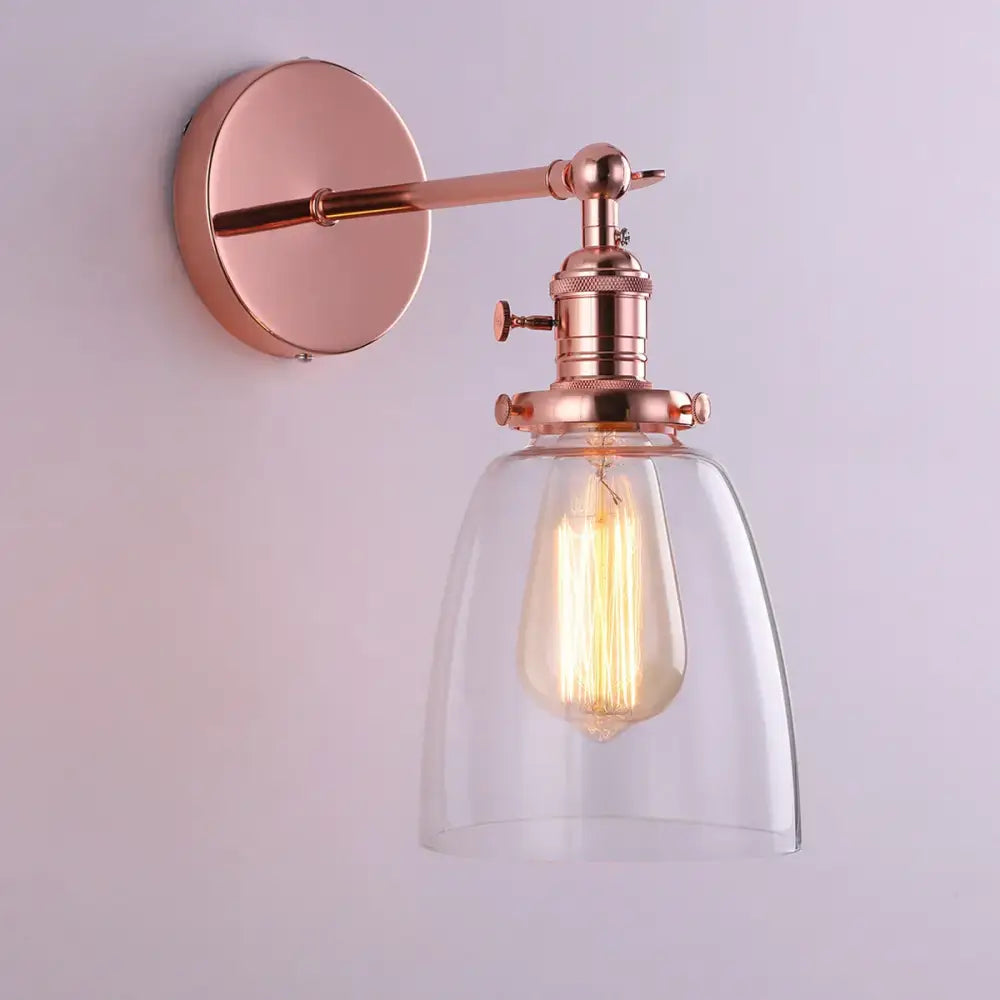 Rose gold vintage-style glass wall lamp with clear shade and exposed filament bulb for living room and bedroom lighting