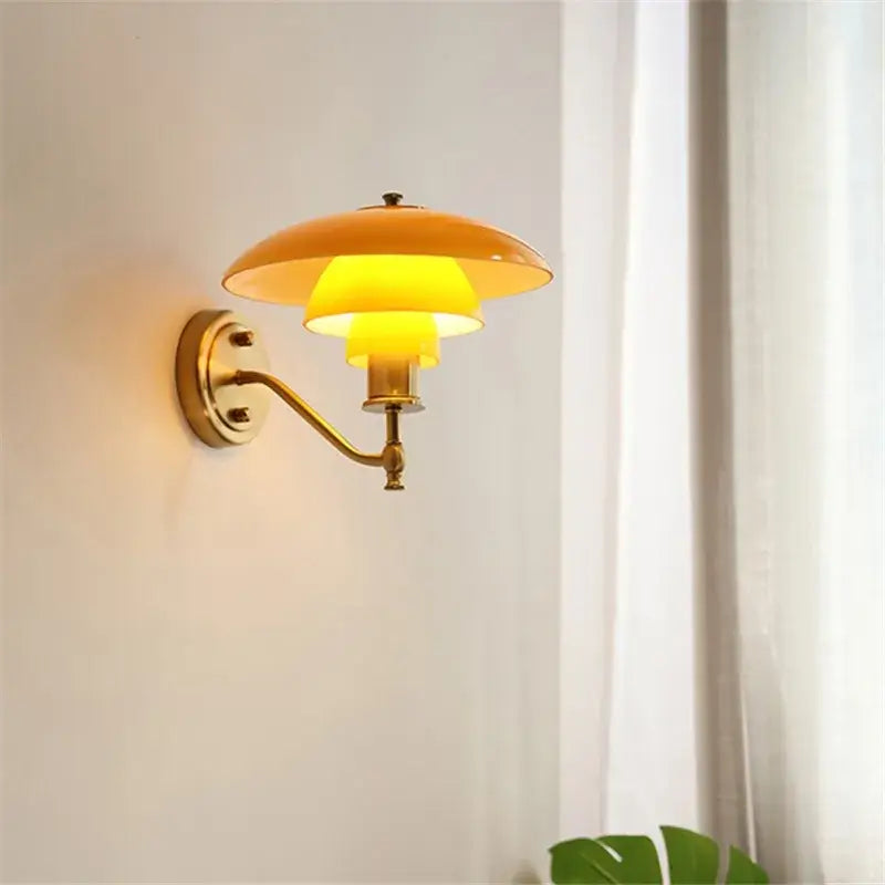 Golden brass wall lamp with warm yellow tiered glass shade decorbites glass wall lamp for living room decor