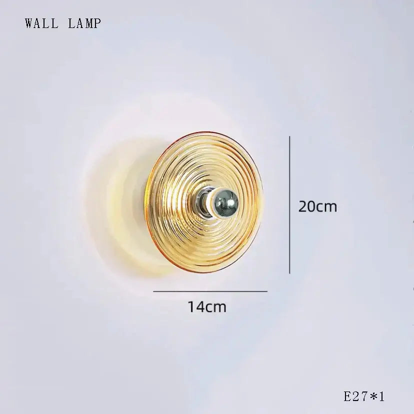 Gold-toned DecorBites glass wall lamp with concentric circular ridges and dimmable LED for living room lighting