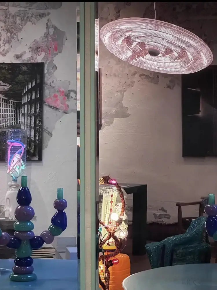 A translucent pink decorbites glass wall lamp with a spiral glass design dimmable for modern living room use