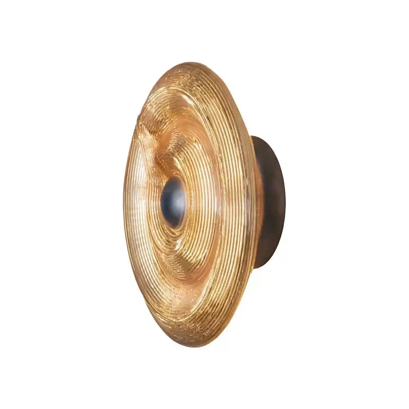 Golden decorbites glass wall lamp with concentrically ridged glass and dark metal backplate for modern living room lighting