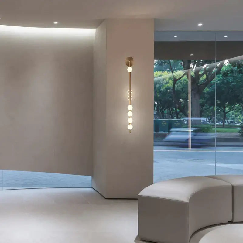 Decorbites glass wall lamp featuring a modern gold-toned metal stem with five frosted glass bulbs for living room use