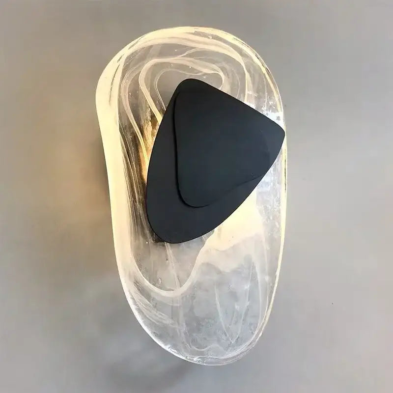 A sleek black triangular decorbites glass wall lamp with a translucent marbled glass wall lamp sconce for indoor use