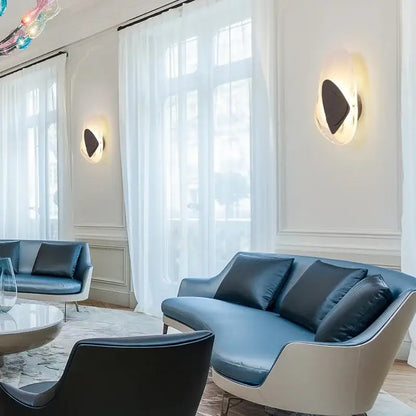 Modern blue leather sofa with sleek white frame and dark cushions beside decorbites glass wall lamp led sconce