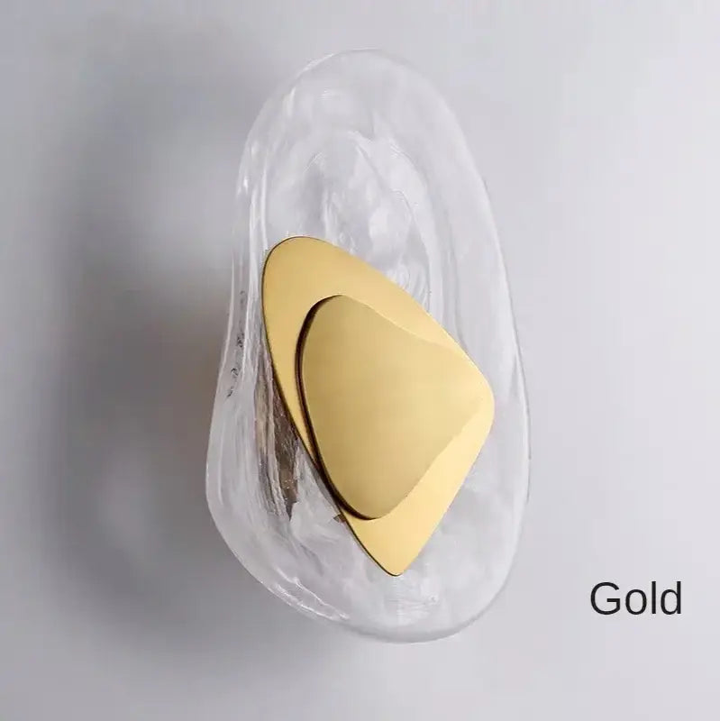 Modern gold-toned decorbites glass wall lamp with sleek triangular metal plate and translucent base for bedroom use