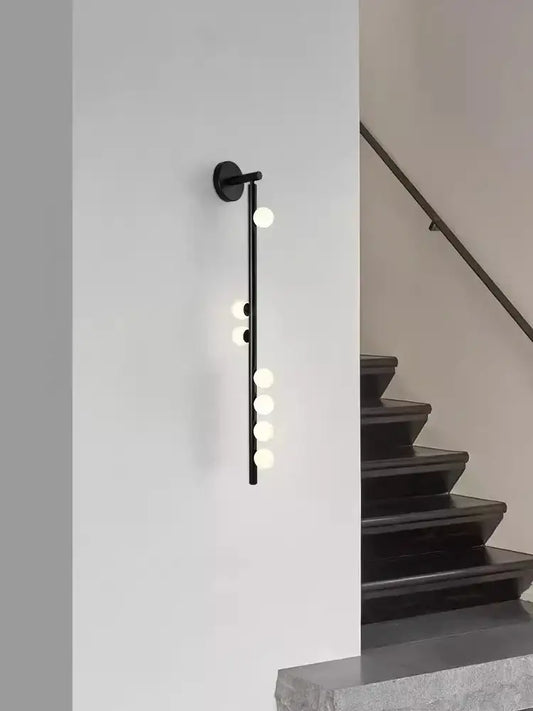 Black decorbites glass wall lamp with five glowing spherical bulbs on minimalist rod for modern living spaces