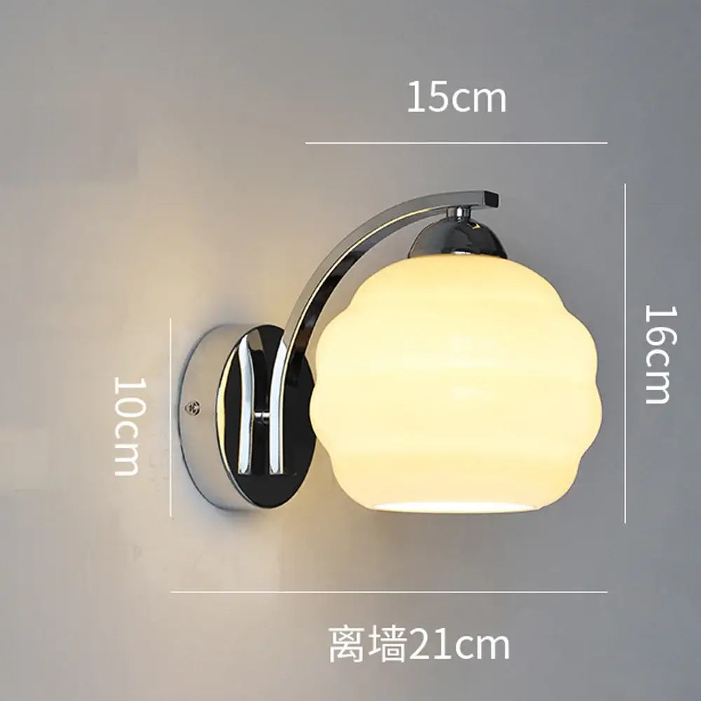 Decorbites glass wall lamp with a curved chrome arm and frosted glass shade emitting warm light for modern wall lighting