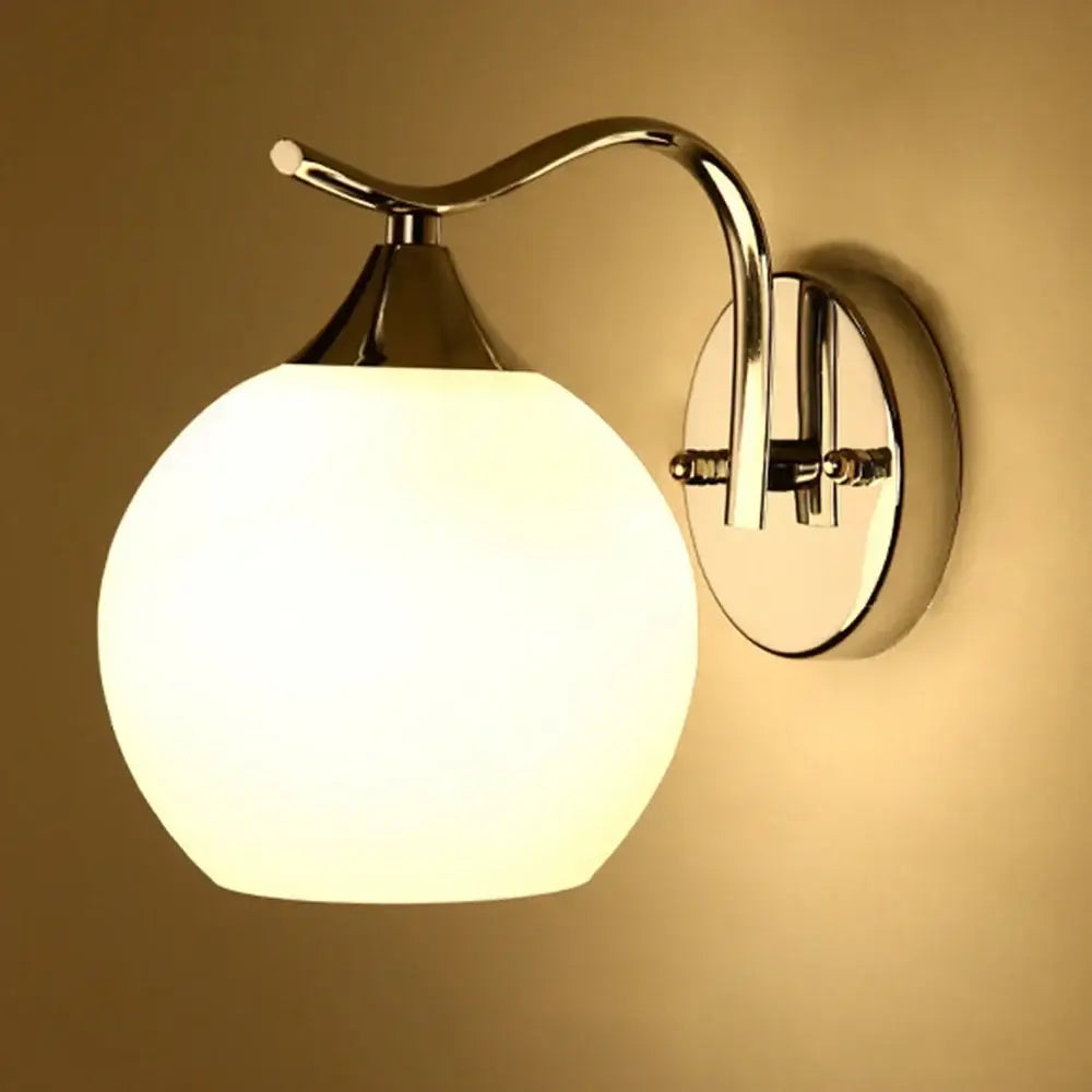 A sleek modern decorbites glass wall lamp with polished chrome and frosted white glass for bedroom or corridor lighting