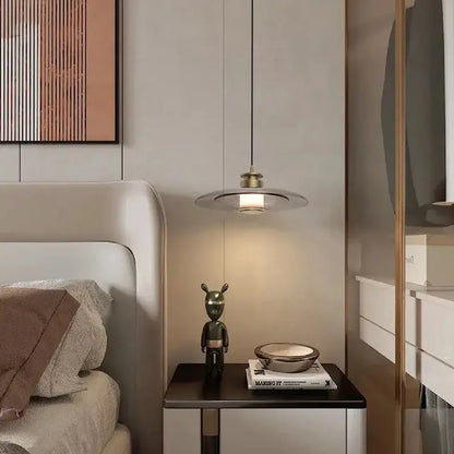 Modern minimalist decorbites glass wall lamp with circular brass shade and thin black cord for living and dining rooms
