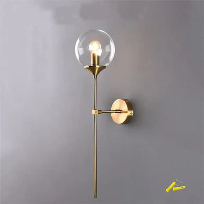 Brass-finished decorbites glass wall lamp with clear glass globe and slender stem for home and bedroom lighting