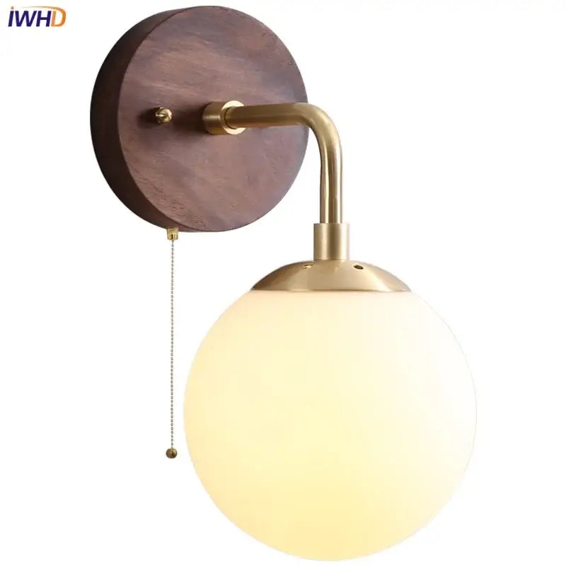 Brass-finished DecorBites glass wall light fixture with round walnut wood backplate and frosted glass globe