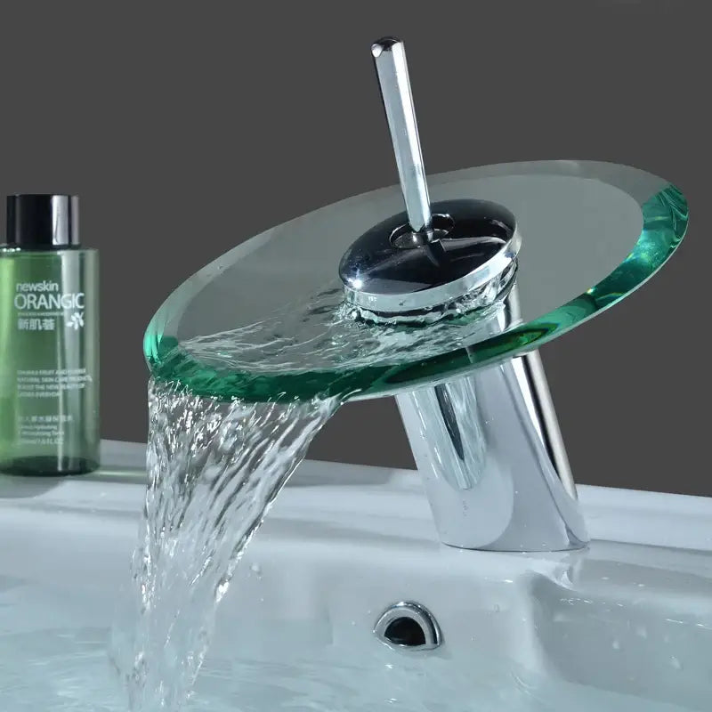 Modern chrome-finished decorbites™ glass waterfall basin sink faucet with transparent green glass spout and flowing water