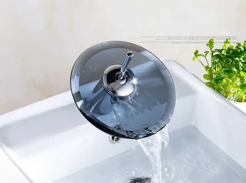 Modern chrome finished decorbites™ basin sink faucet with sleek circular design and dark translucent glass waterfall accent