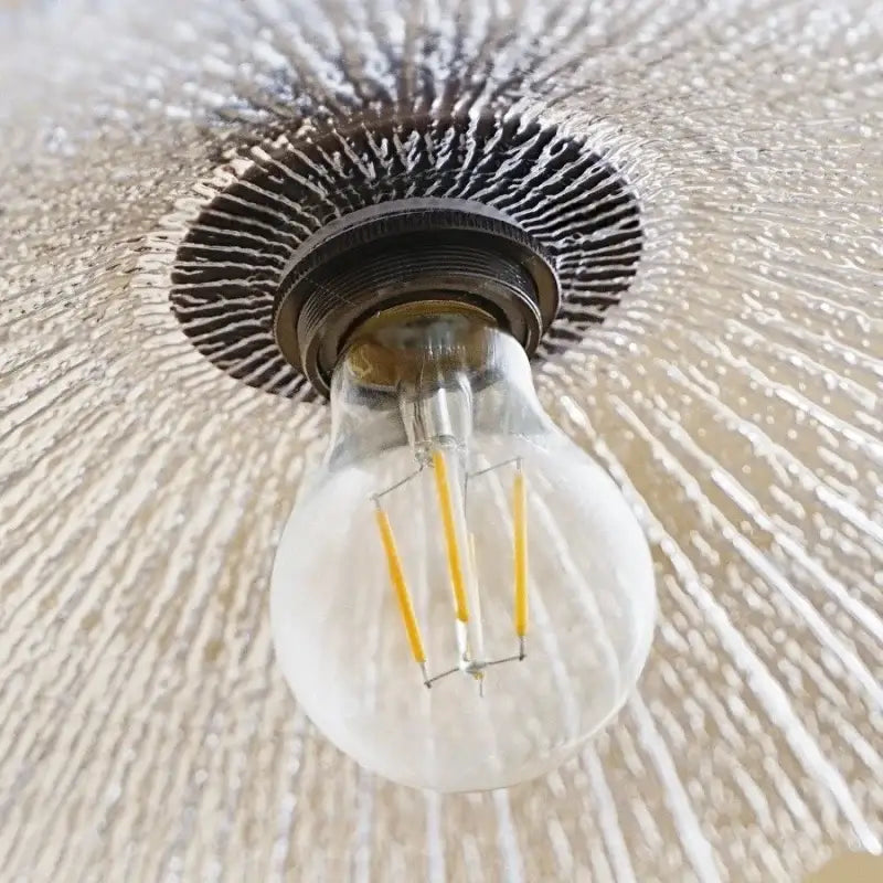 Clear glass led bulb with visible filament threads and dark metal base in DecorBites wood led pendant lights for home decor