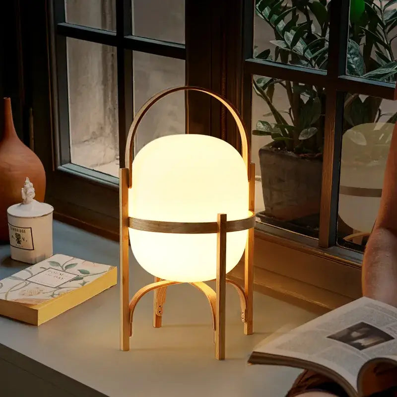 DecorBites™ glass and wood metal table lamp with warmly glowing spherical light and minimalist wooden frame handle