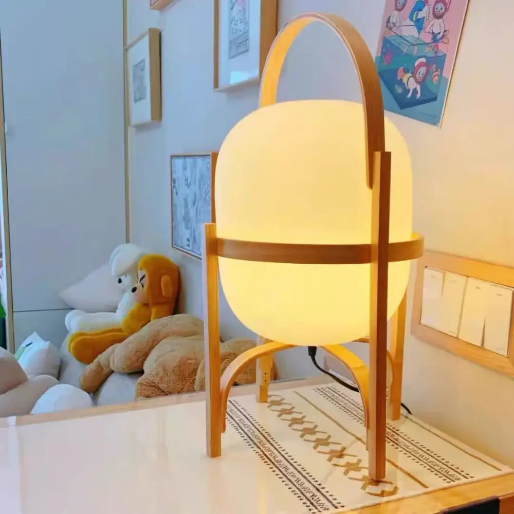 Warm softly glowing decorbites glass and wood metal table lamp with minimalist wooden frame and handle for japanese style room