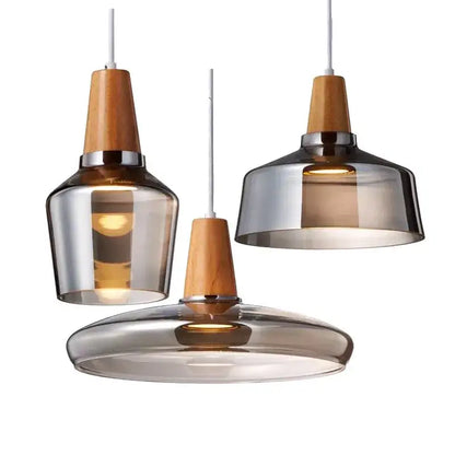 Three modern DecorBites glass pendant lights with smoked glass and warm wood accents for dining and bar areas
