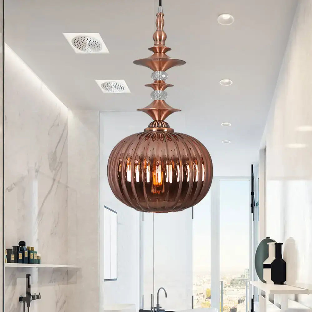 Copper-toned pendant light with faceted ribbed glass globe and crystal accents in chrome copper gold finish for dining room