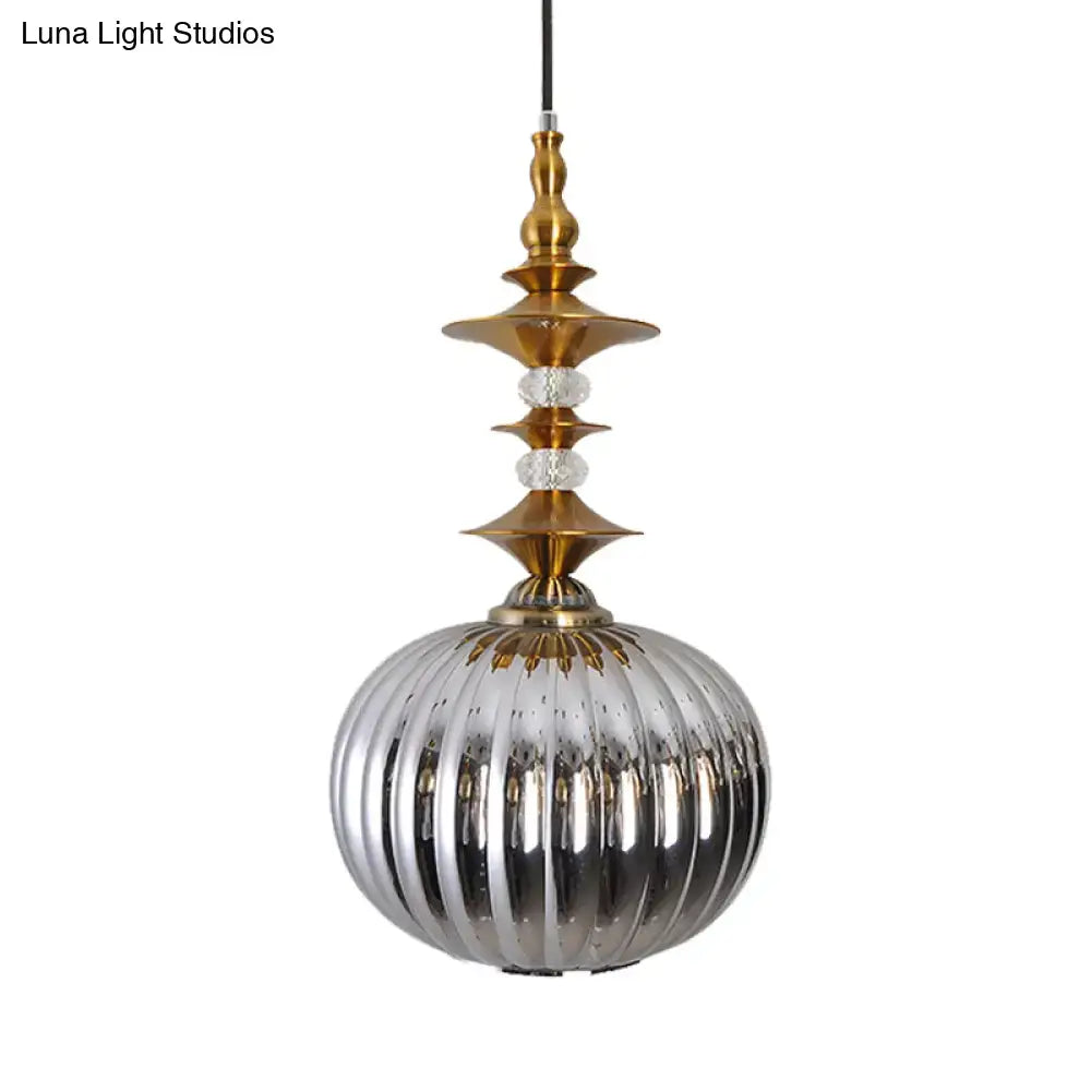 A sleek ribbed silver glass pendant light with brass top and crystal accents in chrome copper gold finish for dining room