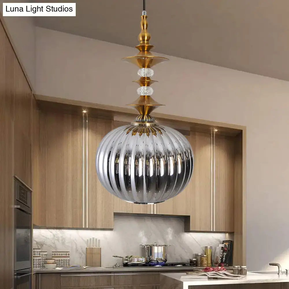 A sleek ribbed silver glass pendant light with chrome copper gold fixture and crystal accents for kitchen or dining room