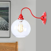 Industrial red metal wall light fixture with clear glass globe and exposed filament bulb for bedroom sconce lighting