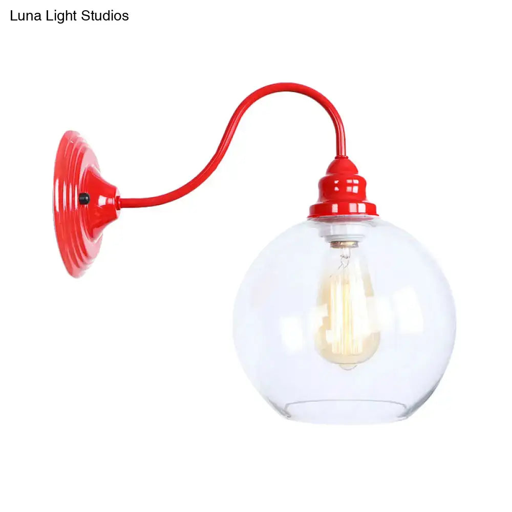 Industrial red metal wall light fixture with curved arm and clear glass globe housing exposed filament bulb for bedroom