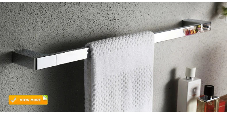 Chrome-finished rectangular towel bar with sleek design holding white towel alongside DecorBites gold brass basin faucet