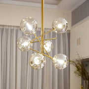 Decorbites gold glass bubble chandelier with six clear glass globe bulbs in a gold-toned starburst design for dining room