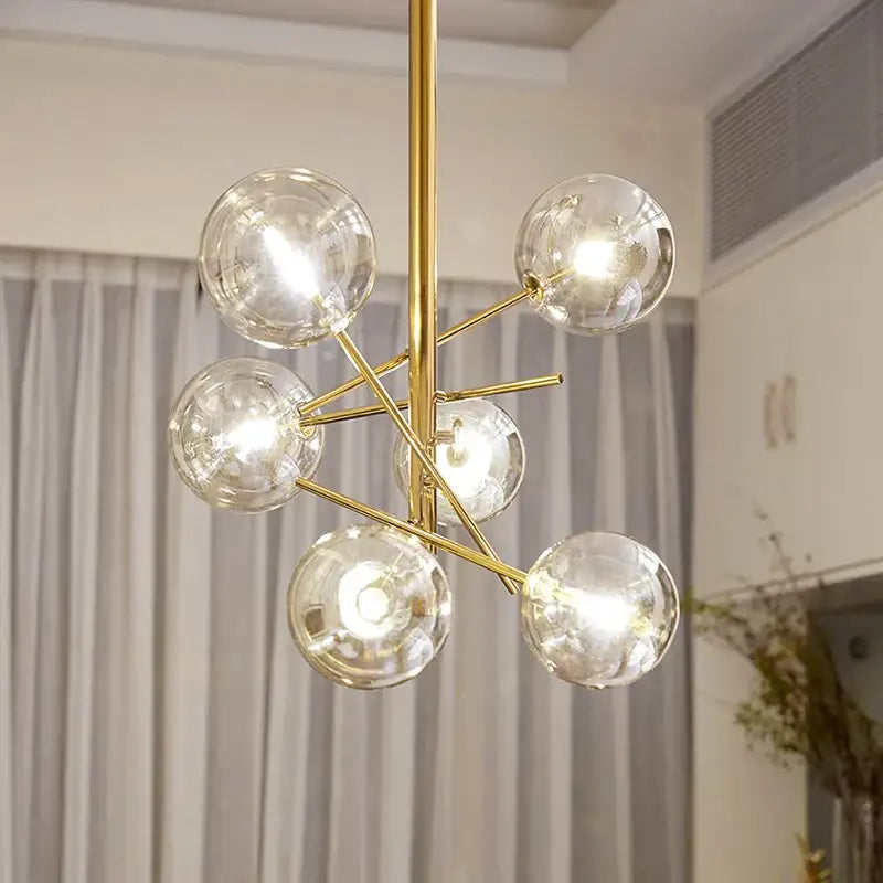 Decorbites gold glass bubble chandelier with six clear glass globe bulbs in a gold-toned starburst design for dining room