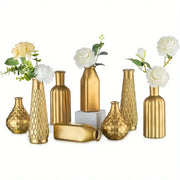 Set of eight gold glass vases with varied geometric designs and white flowers for antique art style home decor