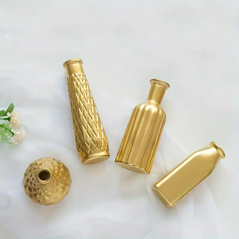 Set of four gold-toned glass vases with varied shapes and textured surfaces for elegant home decor by DecorBites