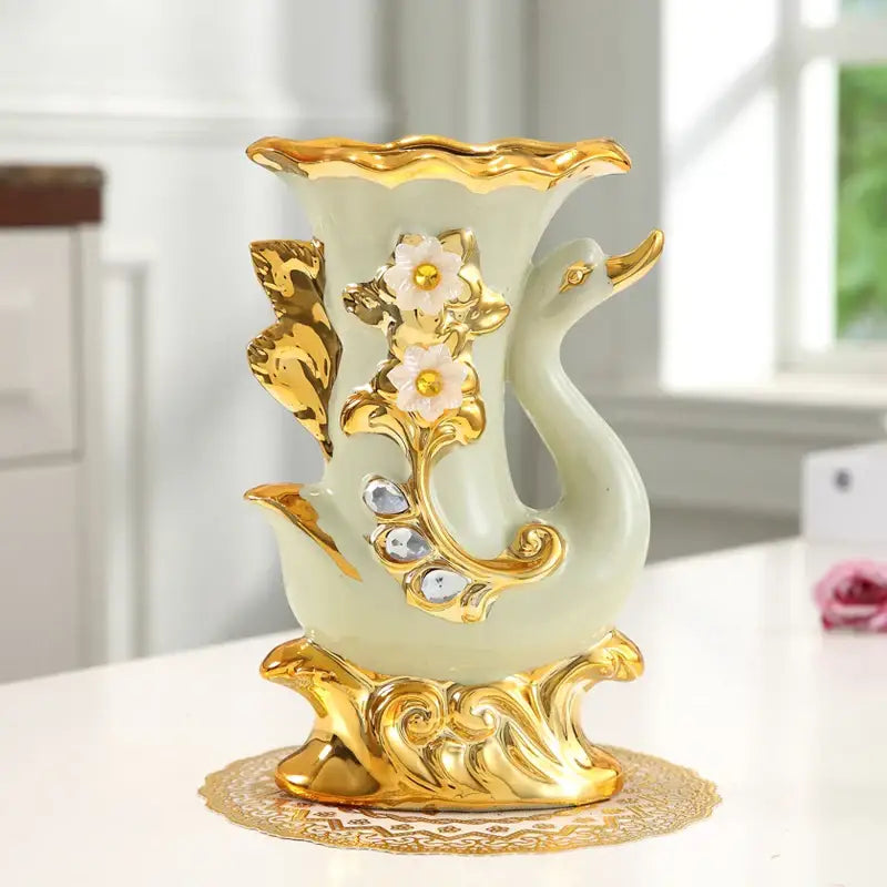 Decorbites gold glass vase shaped like a swan with gold accents and white floral embellishments for stylish decor