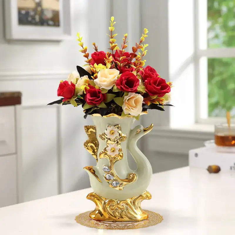 Elegant light green ceramic glass vase with gold ornate detailing holding vibrant artificial roses for stylish decor