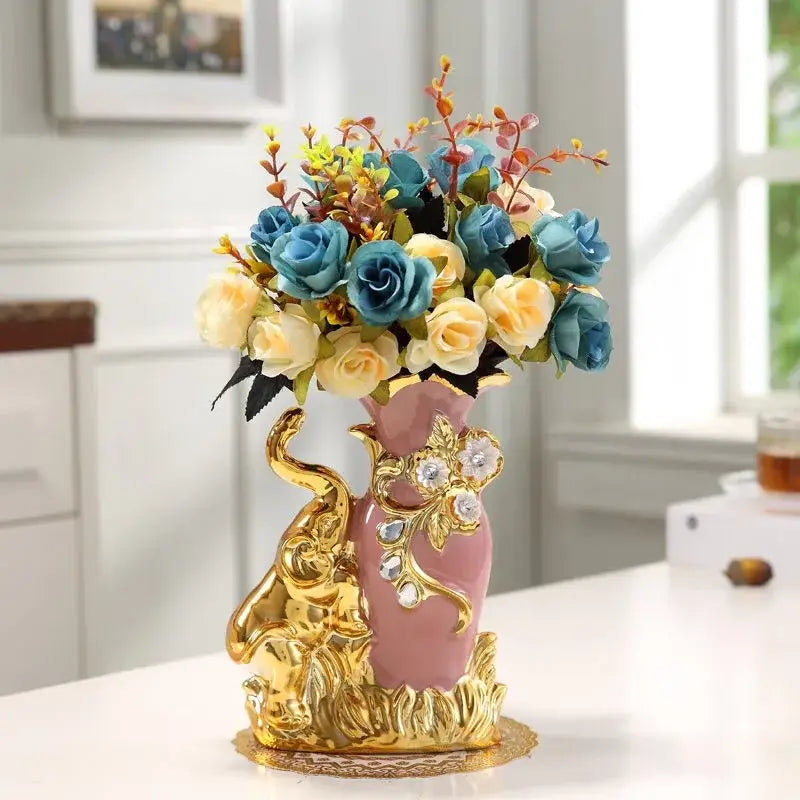 Decorbites gold glass pink ceramic vase with gold elephant embellishments holding blue and cream artificial roses