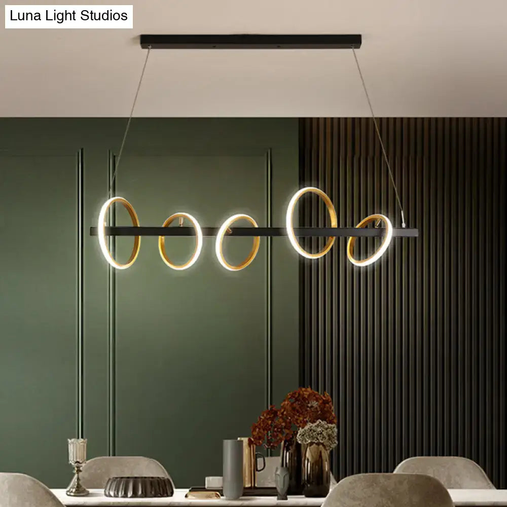 Modern black and gold metal ceiling pendant with simple circles design and warm light for dining room island illumination