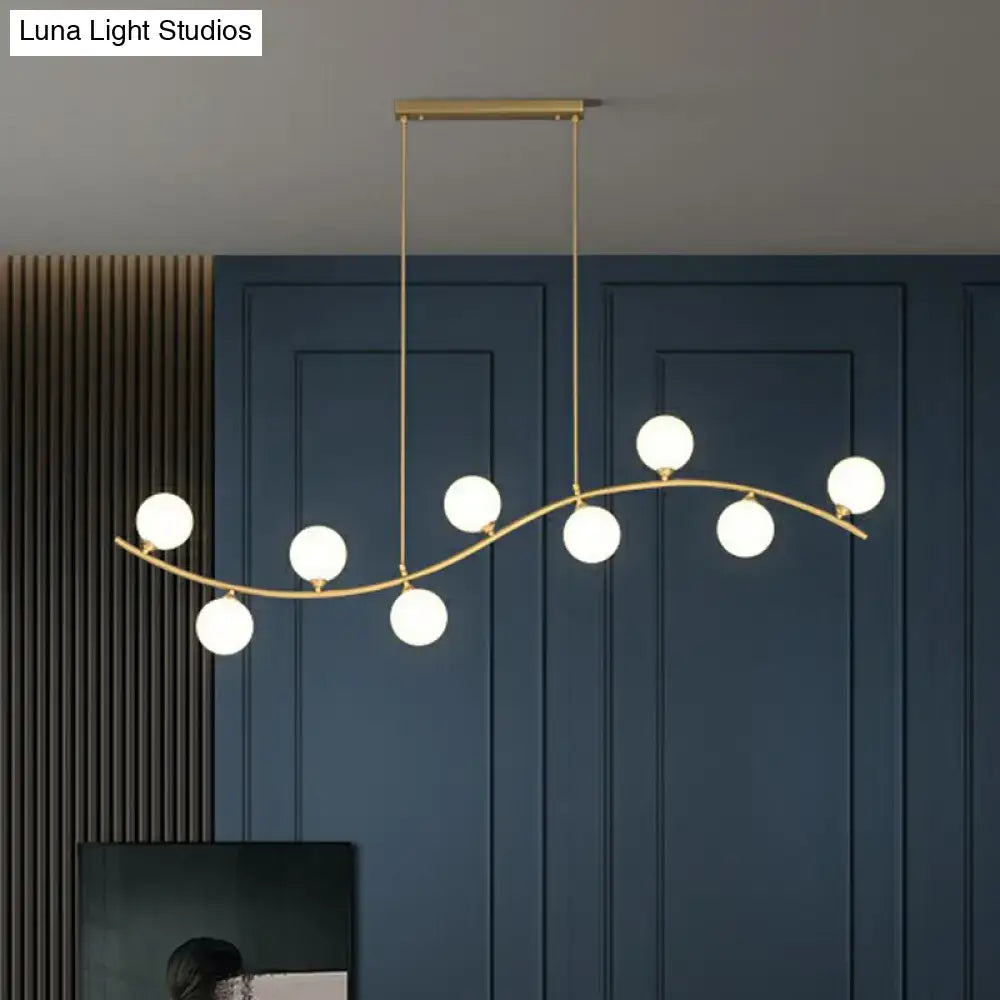 DecorBites gold milk ball glass pendant lighting with seven white glass bulbs on a minimalist wavy ceiling arm