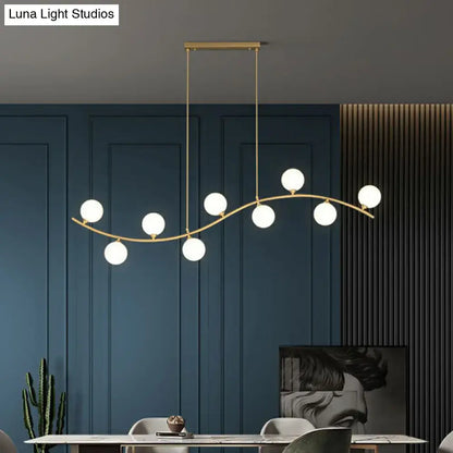 Gold-toned DecorBites minimalist wavy ceiling pendant with seven white milk ball glass bulbs for dining room island lighting