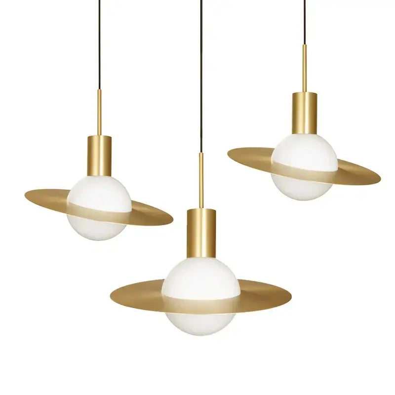 Three decorbites gold modern pendant lights with glass filament bulbs and gold metal fixtures for dining room use